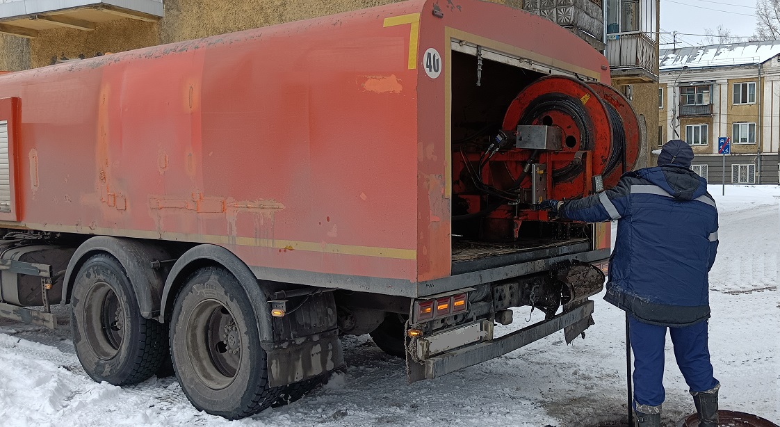 Каналопромывочная машина и работник прочищают засор в канализационной системе в Гвардейске
