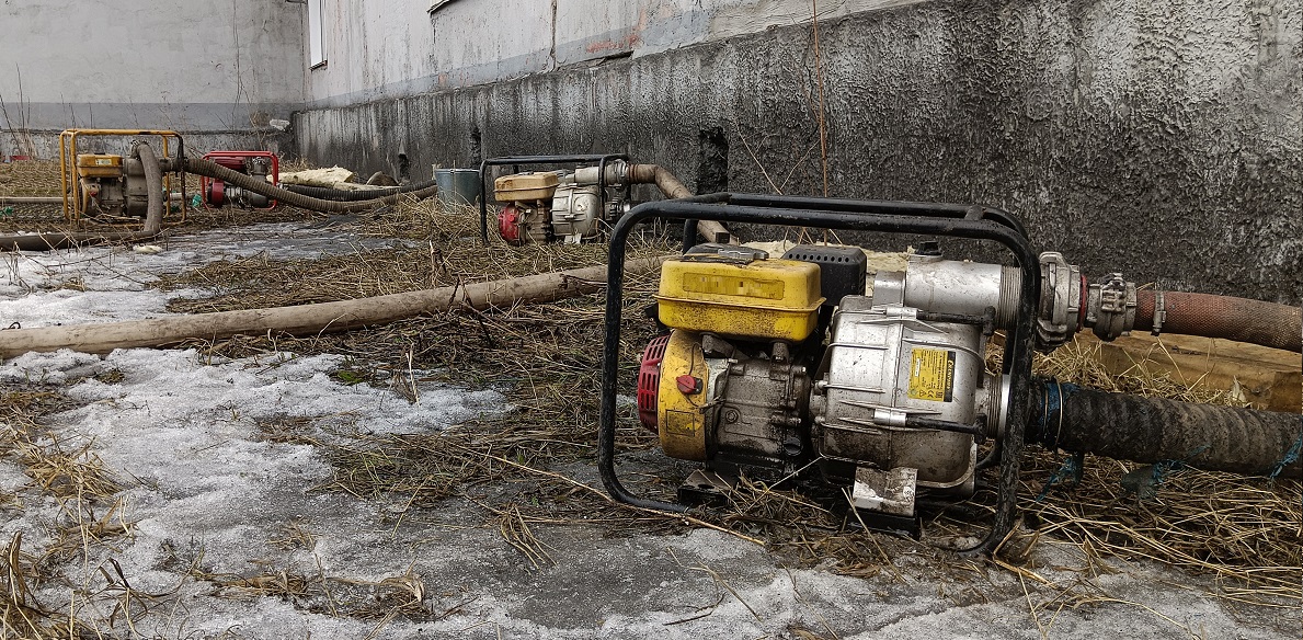 Откачка мотопомпами талой воды из подвала дома в Озерске